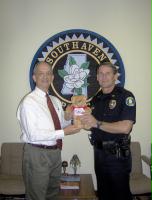 Barry donations Good Neighbears to Southaven Police Chief, Tom Long.